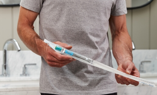 man holding gentlecath glide male hydrophilic catheter
