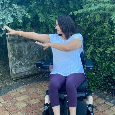 Meena demonstrating an adaptive yoga pose for people with a spinal cord injury